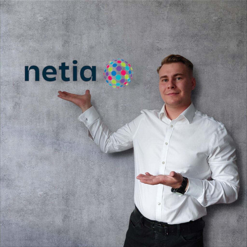 Zdjęcie przedstawiające przedstawiciela firmy Netia wskazującego na logo firmy