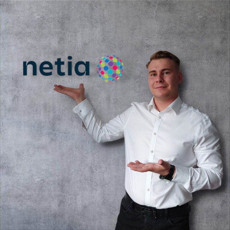 Zdjęcie przedstawiające przedstawiciela firmy Netia wskazującego na logo firmy